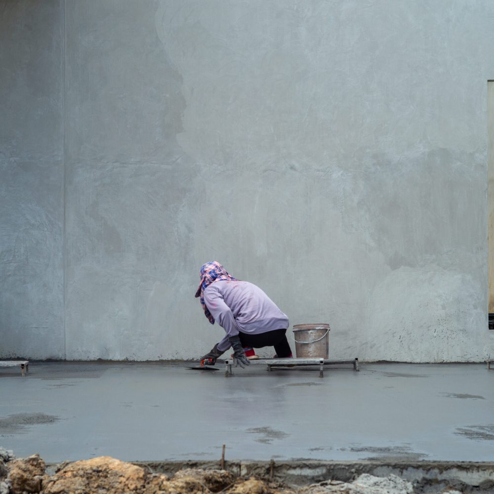 Back portrait group of workers use trowel for flooring the cement suface